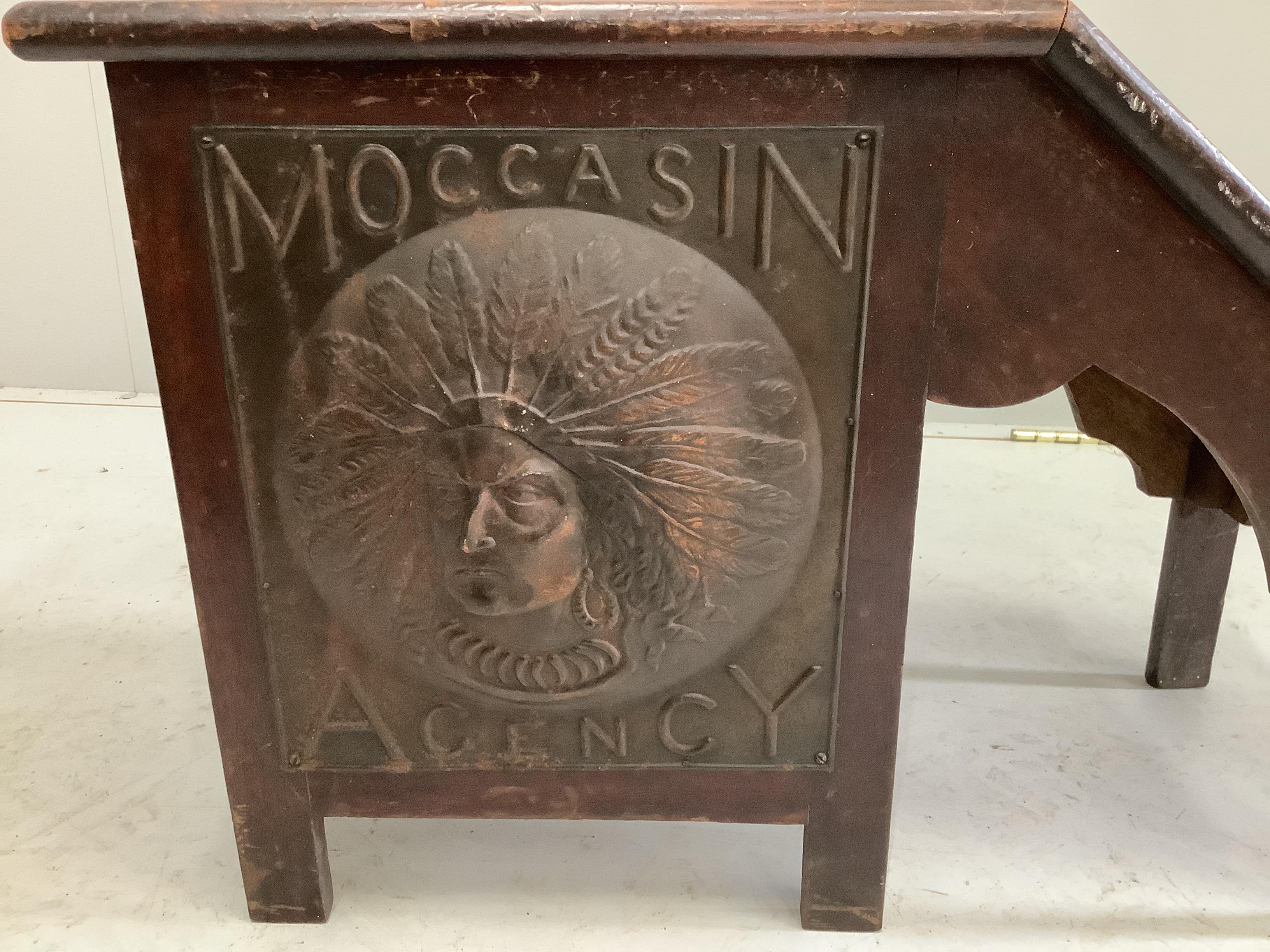 An early 20th century American Moccasin Agency embossed metal mounted shoe shine seat, width 64cm, depth 41cm, height 41cm
